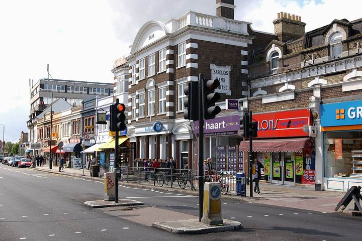 Shops and traffic lights on Coombe Lane in Raynes Park, SW20